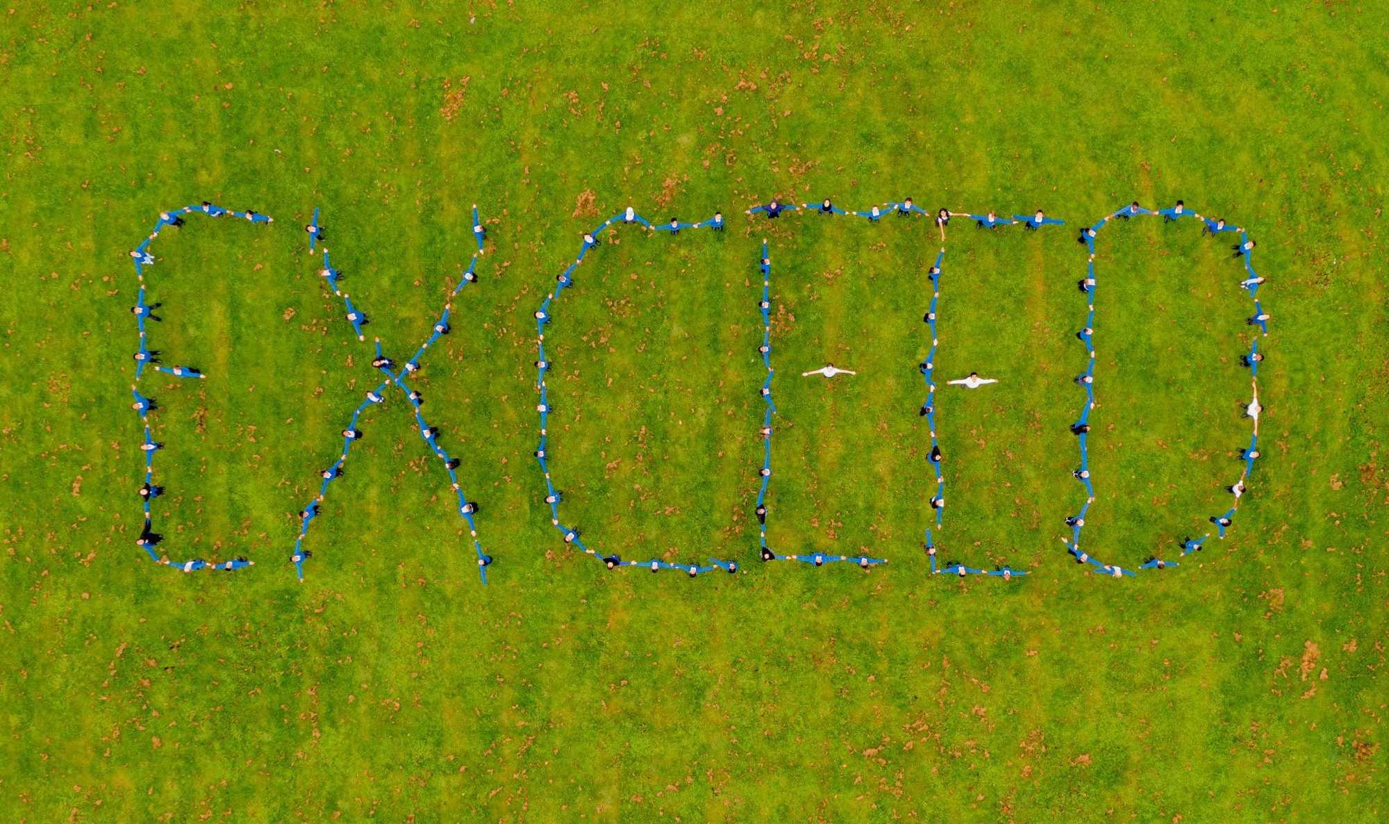 aerial image of children forming the word 'Exceed'